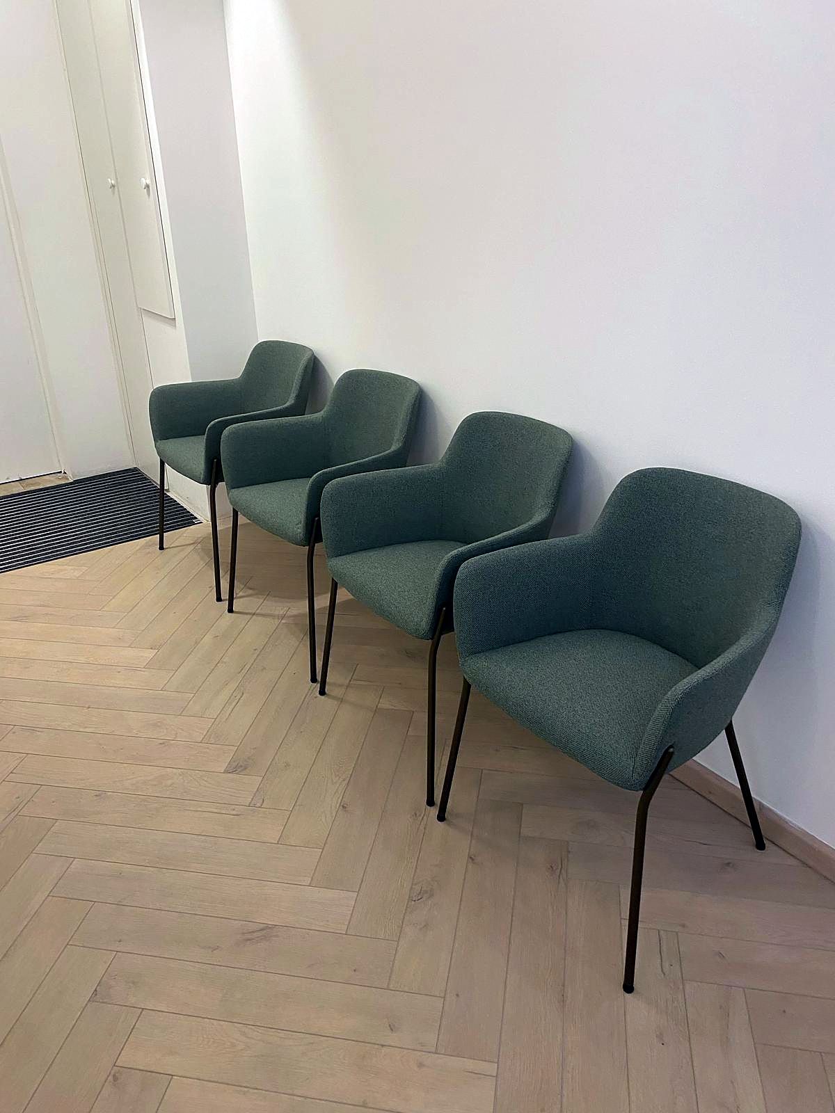Attente en circulation : fauteuils vert sauge alignés le long d’un couloir
