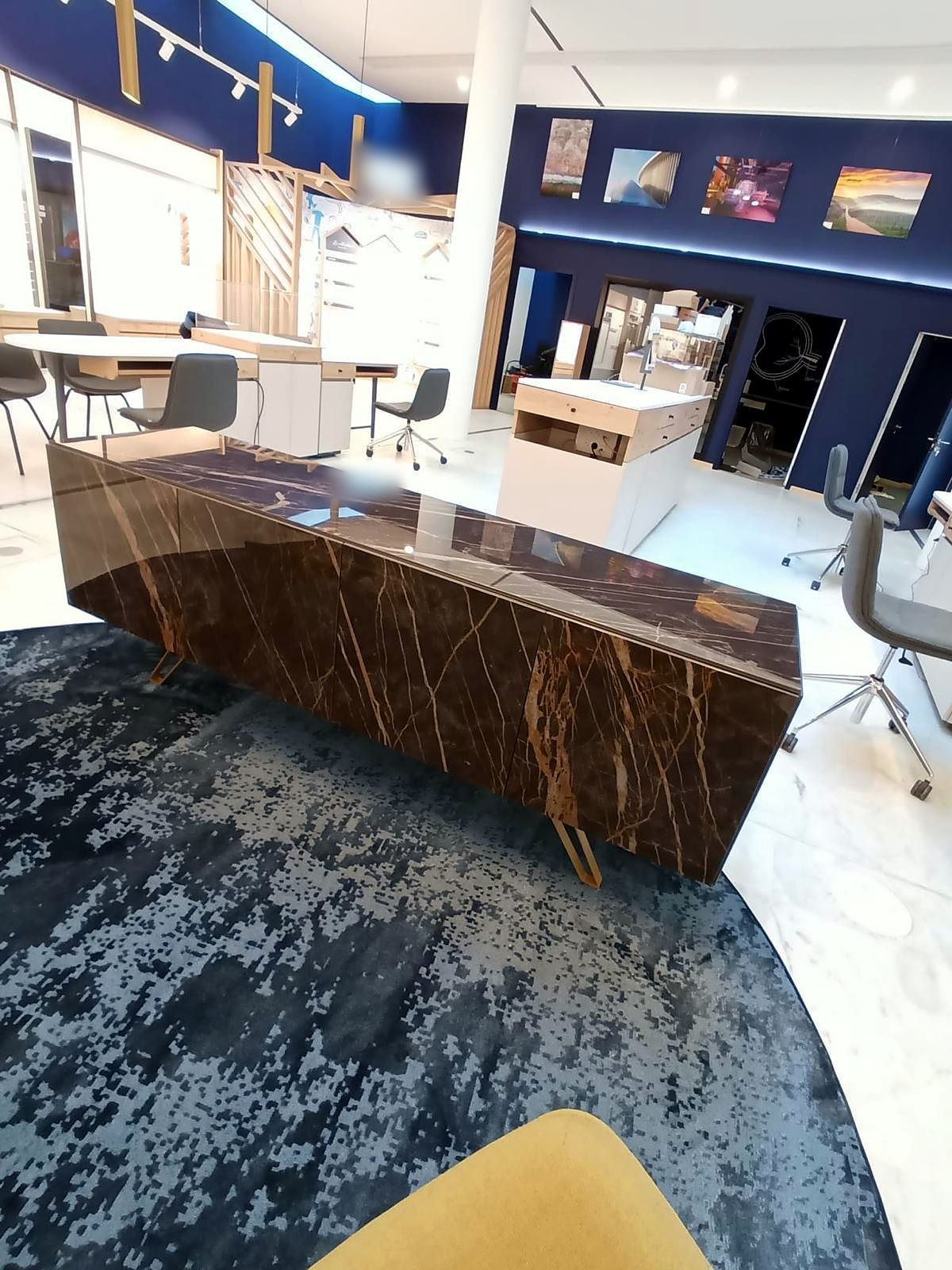 Banque d’accueil plaquée marbre brun sur un tapis graphique