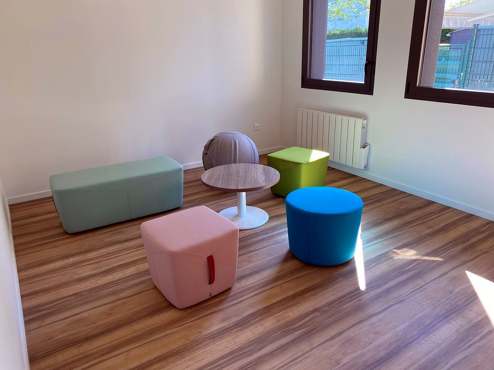 Espace informel : poufs de couleur et table haute ronde