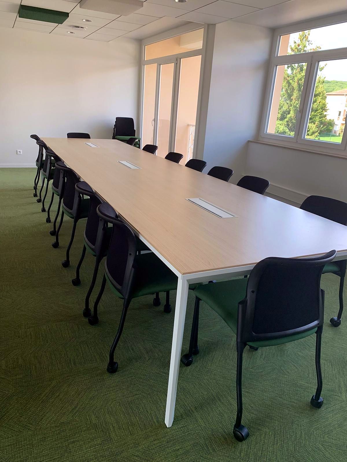 Salle de conseil : grande table plateau chêne clair, sièges visiteurs sur roulettes